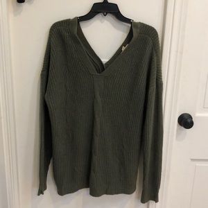 Coverstitched green sweater with buttons down back